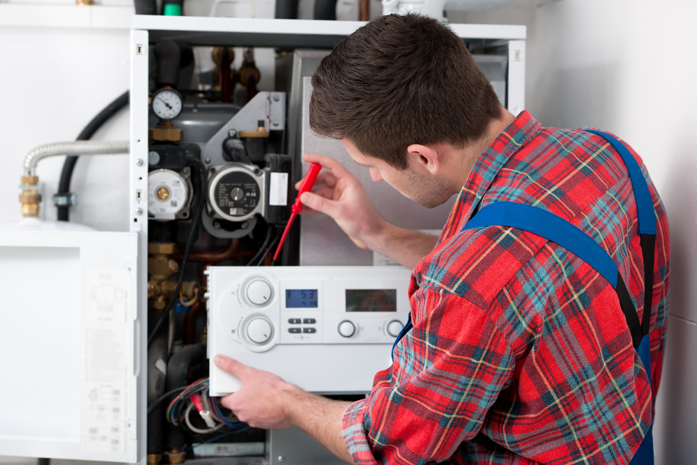 image of a heater repair person fixing a heating system